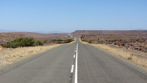 Road passing through landscape against clear sky