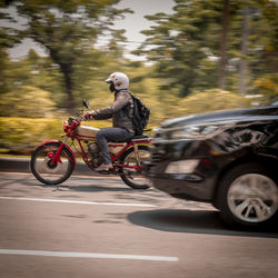 Side view of man riding motorcycle on road