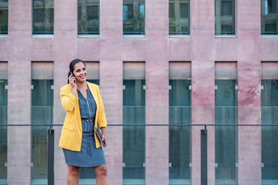 Full length of woman standing on mobile phone