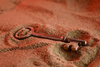Close-up of rusty chain on sand