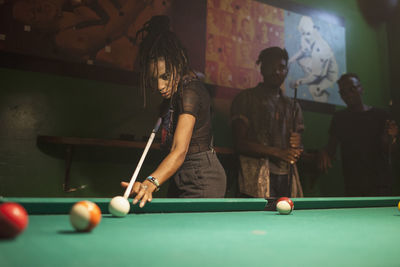 A young woman playing pool.