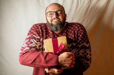 Portrait of smiling man standing against wall