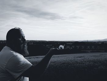 Rear view of man on rock against sky