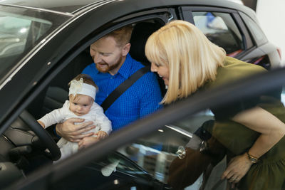 Family choosing new family vehicle in car dealership