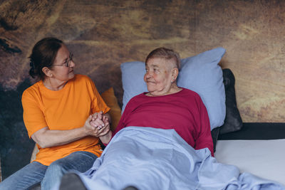 Portrait of smiling couple relaxing on bed at home