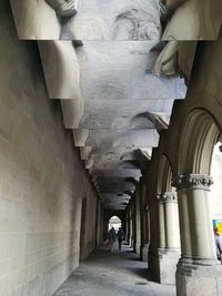 Rear view of people walking in corridor of building