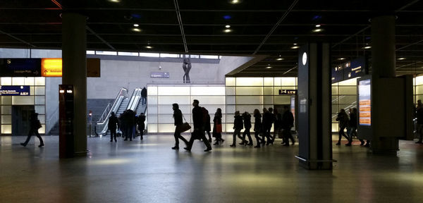 Silhouette of people walking in subway station