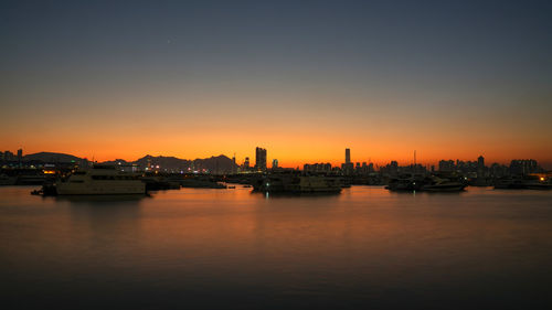 Scenic view of illuminated buildings against sky during sunset