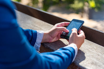 Midsection of man using mobile phone