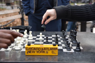 Cropped hands of friends playing chess