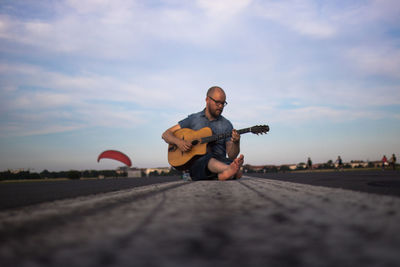 Full length of boy playing on landscape against sky