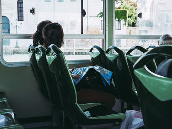 Rear view of woman sitting in bus