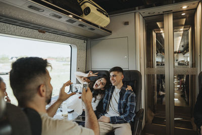 Father photographing son and daughter having fun in train