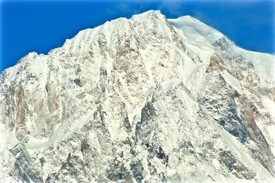 Snow covered rock against sky