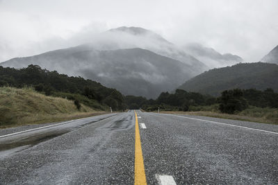 Empty road leading towards mountains