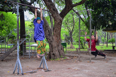 Woman standing by tree against plants