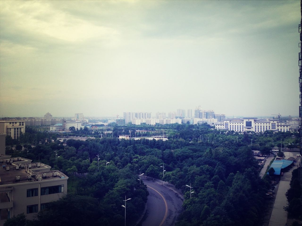 building exterior, architecture, built structure, city, tree, sky, cityscape, high angle view, road, street, residential building, transportation, residential district, residential structure, city life, car, building, cloud - sky, outdoors, day