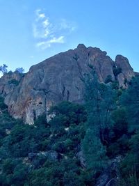 Low angle view of mountain against blue sky