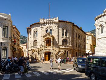 People on street against buildings in city