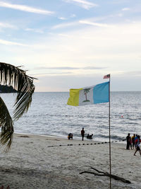 People at beach against sky