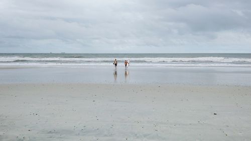 Scenic view of beach against cloudy sky