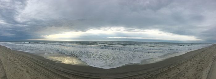 Scenic view of beach against dramatic sky