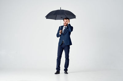 Full length of man holding umbrella