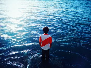 Rear view of woman standing in sea