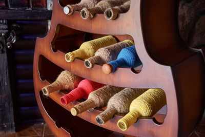 Colorful wine bottles wrapped in rope on stand. interior design element