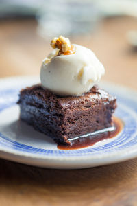 Close-up of chocolate brownie with vanilla ice cream in plate on table