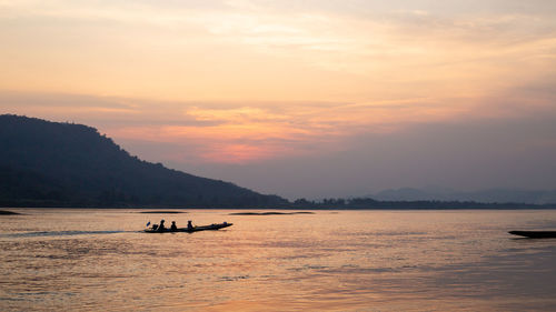 Silhouette boat in sea against sky during sunset