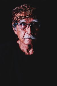 Portrait of senior man against black background