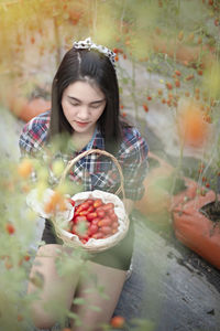 Beautiful young woman holding red fruit