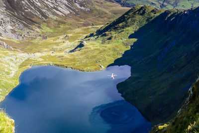 Aerial view of rescue helicopter flying over lake at snowdonia national park