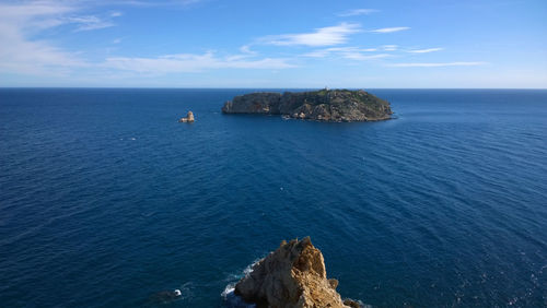 High angle view of rock formation in sea against sky