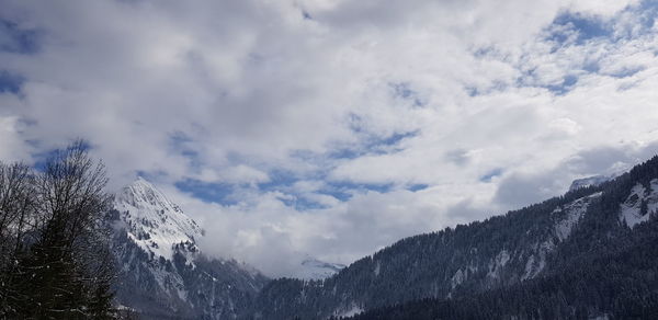 Low angle view of snowcapped mountains against sky