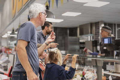 Customers at deli counter in supermarket