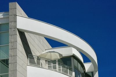 Low angle view of modern building against clear blue sky