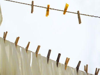 Low angle view of clotheslines against clear sky