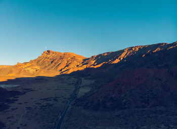 Scenic view of snowcapped mountains against clear blue sky