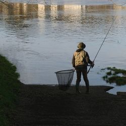 Rear view of man fishing at lake