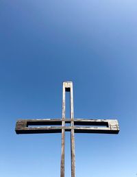 Low angle view of cross against clear blue sky