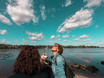 Woman with friends in water against sky