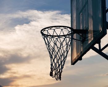 Low angle view of basketball hoop against sky during sunset