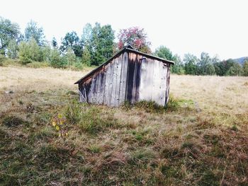 Abandoned house on grassy field