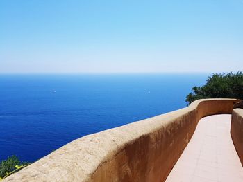 Scenic view of swimming pool by sea against clear sky