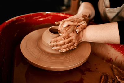 Midsection of man making pottery wheel