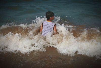 Rear view of boy on beach