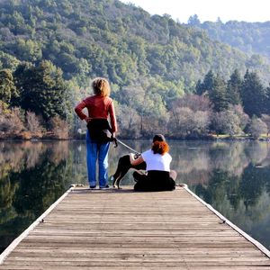 Rear view of people relaxing on lake