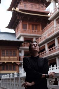 Full length of woman standing against building